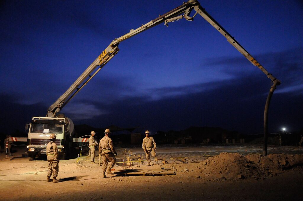 Concrete pump and boom operating while pressure is monitored through the pumping system